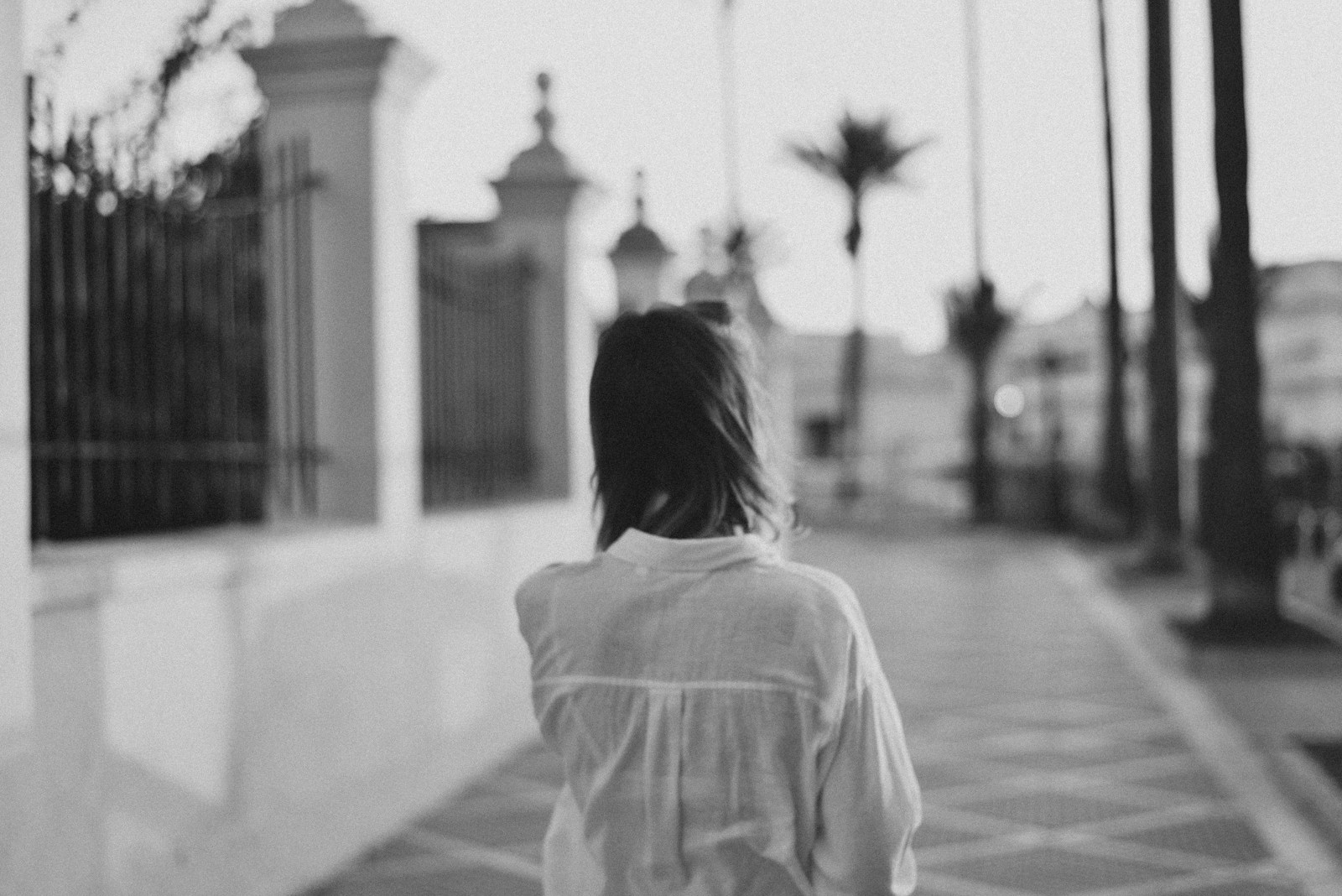 a woman walking down a sidewalk next to a building